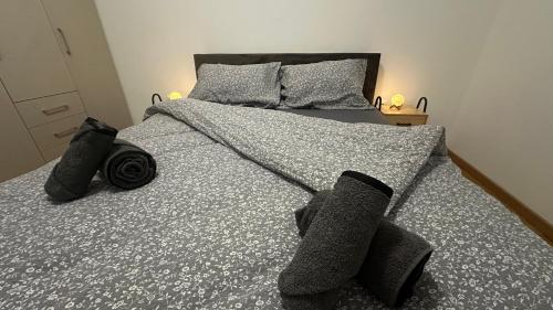 un letto con piumone grigio e cuscini sopra di Sky View - stan na dan Banja Luka a Banja Luka