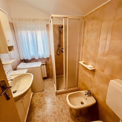 a bathroom with a shower and a toilet and a sink at Villa Angiolina in Bardolino