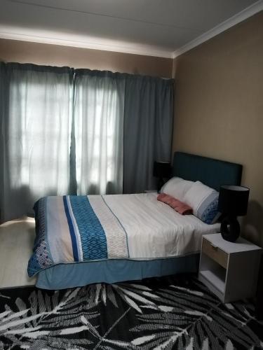 een slaapkamer met een bed en een raam bij Two Lilies in Vosburg