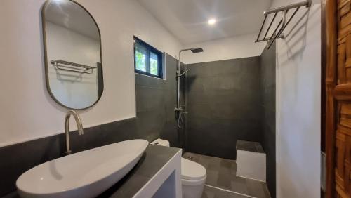 a bathroom with a white sink and a mirror at Molmol Cafe in Larena