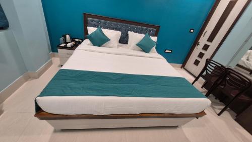 Un dormitorio con una cama grande con paredes azules. en Hotel City Palace, en Bhagalpur