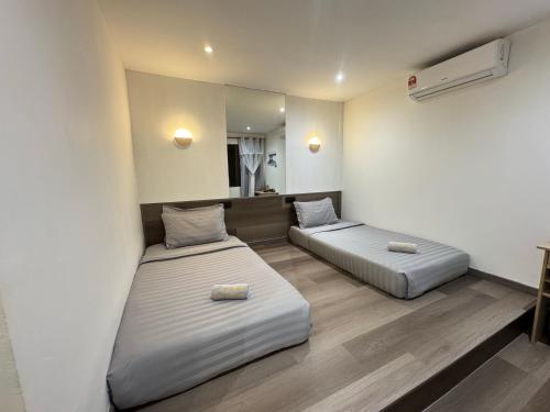 小竹林民宿 bamboo homestay 仙本那semporna 独栋房源 华语交流 步行码头10分钟 步行海鲜市场5分钟 في سيمبورنا: غرفة بها سريرين ومرآة