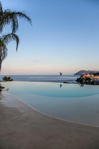 a beach with a bird flying over the water at Hotel Villa Enrica - Aeolian Charme in Lipari