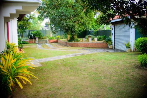 a yard with a house with a garage and a fence at The Cozy Villa in Ambalangoda