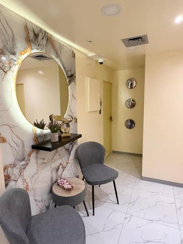 ein Wartezimmer mit zwei Stühlen und einem Spiegel in der Unterkunft PrimeLuxe Stay by Lavishhub in Abu Dhabi
