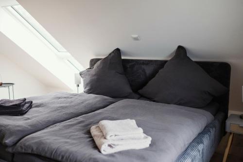 een bed met twee kussens en twee handdoeken erop bij Ferienwohnung Habichthorst in Naumburg