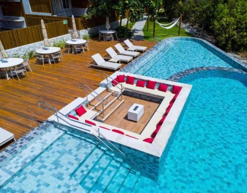 une grande piscine avec des chaises et des tables. dans l'établissement Lanai Imbassai, à Mata de São João