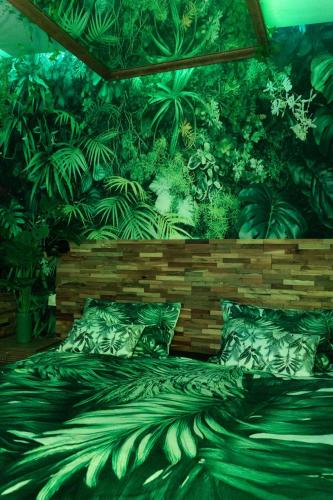 a bedroom with a jungle themed wall with a bed at Jungle Room in Perpignan