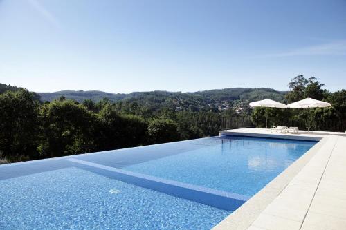 a swimming pool with a view of the mountains at Encosta Dos Túneis - Turismo E Lazer in Sever do Vouga