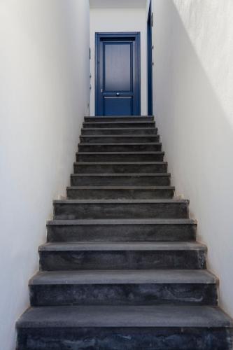 a staircase with a blue door at Hotel Cutimare - Aeolian Charme in Acquacalda
