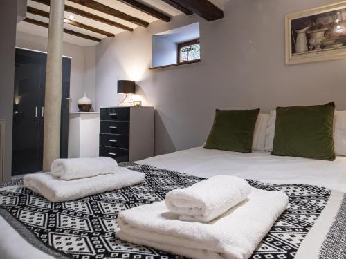 een slaapkamer met een bed met handdoeken erop bij Blists Hill Cottage Near Ironbridge Victorian Museum in Telford