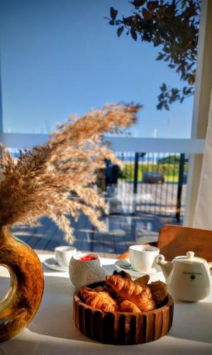 Best Western Premier A Storia Solenzara في ساري سولينزارا: طاولة مع وعاء من الكرواسون وطبق من الطعام