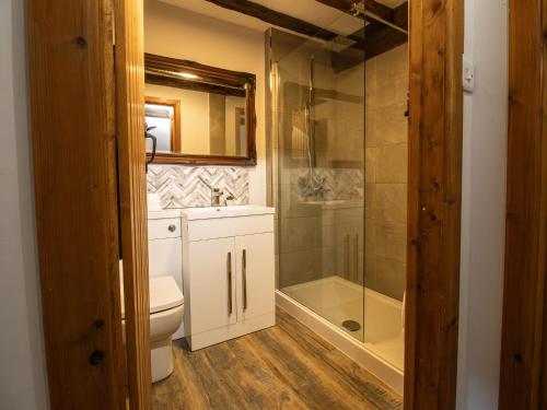 een badkamer met toilet en glazen douche bij Blists Hill Cottage Near Ironbridge Victorian Museum in Telford