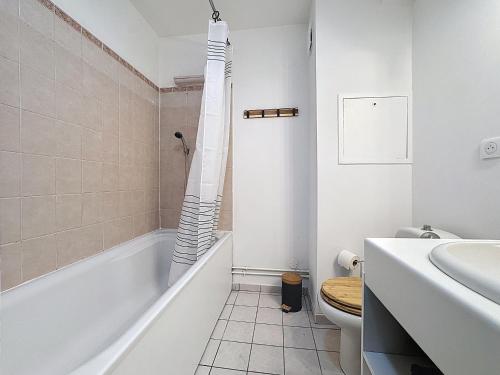 een badkamer met een bad, een toilet en een wastafel bij Studio Moderne avec jardin et garage in Nanterre