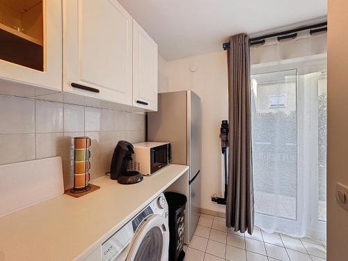 een keuken met een wasmachine en een magnetron bij Studio Moderne avec jardin et garage in Nanterre
