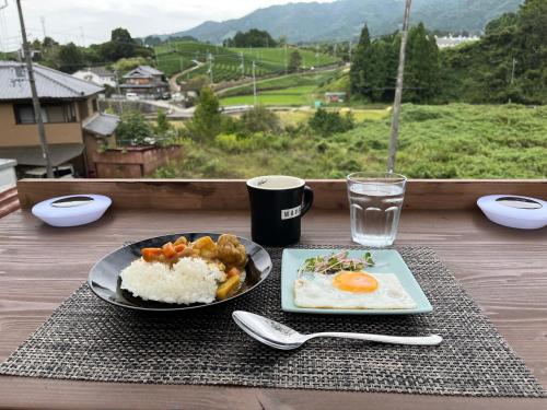 a plate of food with rice and eggs and a glass of water at Stay at matcha fields in Wazuka
