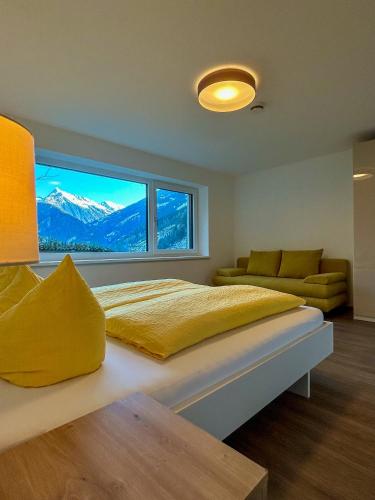a bedroom with a bed and a large window at MOUNTAIN HOME apartment in Finkenberg