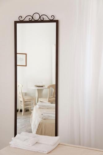 a mirror in a room with a bed and a table at Hotel Villa Enrica - Aeolian Charme in Lipari