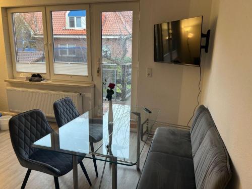 een glazen tafel en 2 stoelen in de woonkamer bij Haus Monika in Juist