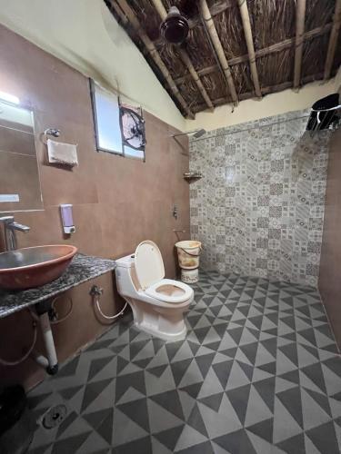 a bathroom with a toilet and a sink at Gramya Resort in Alwar