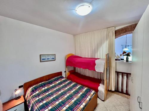 a small bedroom with a bed and a window at Casa Ariel - Elba Affitti in Rio nellʼElba