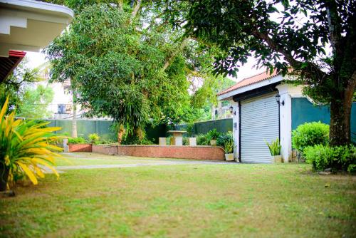 a yard with a house with a garage and a fence at The Cozy Villa in Ambalangoda