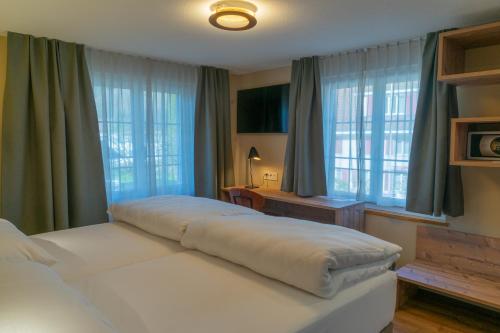 a bedroom with two beds and two windows at Gasthof zum Reh - Self Check-in 