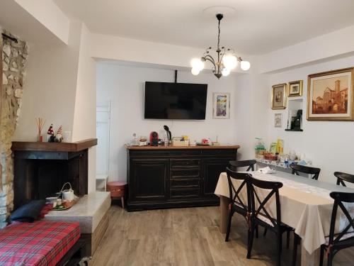 een woonkamer met een eettafel en een televisie bij Numero 33 in Cori