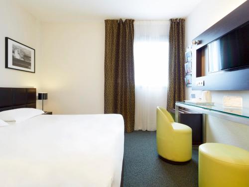 Un ou plusieurs lits dans un hébergement de l'établissement Kyriad Hôtel Orly Aéroport - Athis Mons