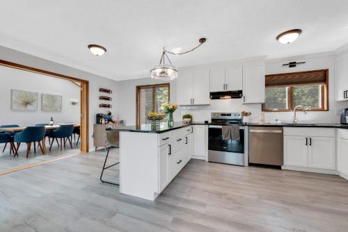 an open kitchen and dining room with white cabinets at Lakefront Big Bass Lake Dock Games in Gouldsboro