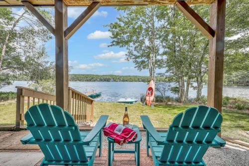 a patio with two chairs and a bottle of wine at Lakefront Big Bass Lake Dock Games in Gouldsboro