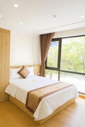 a bedroom with a large bed with a large window at Đức Khôi Hotel in Cao Bằng