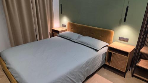 ein Schlafzimmer mit einem großen Bett mit zwei Nachttischen in der Unterkunft Centro & Mare - Rooms - Suites - Garage in Termoli