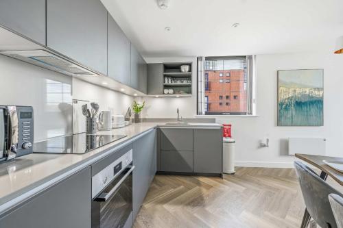 a large kitchen with white cabinets and a sink at Spacious & Modern 2BED Apartment in Birmingham in Birmingham