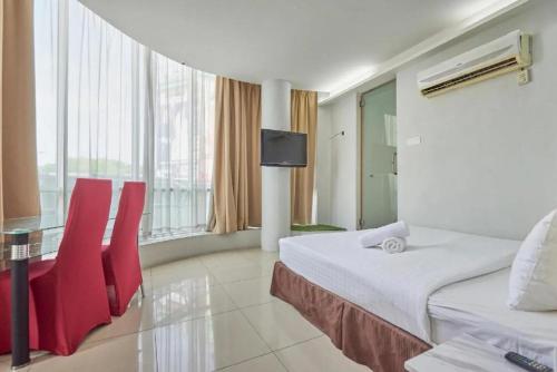 科塔达曼萨拉Swing & Pillows - Kota Damansara的酒店客房,配有床铺和红色椅子