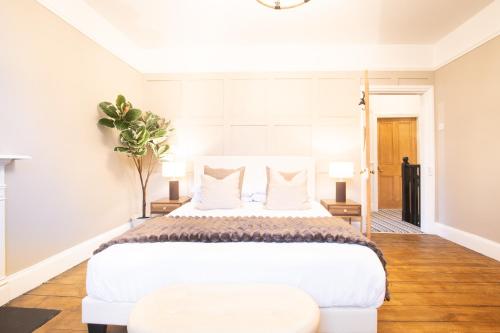 a bedroom with a large white bed and a table at Northern Hideaways St Cuthberts, Seahouses in Seahouses