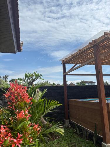 Blick aus einem Garten mit Pergola und Blumen in der Unterkunft Adiuma Cottage Ubud in Ubud