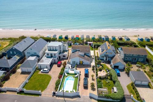 an aerial view of a house on the beach at Vibrant Seafront Home for 10 with Pool in East Wittering