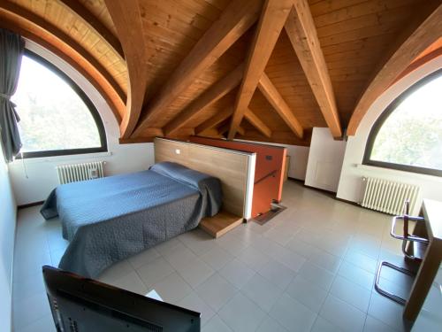 a bedroom with a bed and a desk and two windows at Residence Le Volte Apartments in Parma