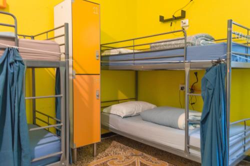 Rúm í herbergi á Home Genoa Hostel