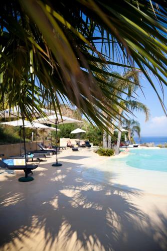 a view of a beach with umbrellas and the ocean at Hotel Villa Enrica - Aeolian Charme in Lipari