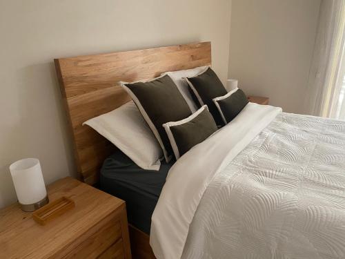 a bedroom with a bed with a wooden headboard and pillows at Banksia Hideaway in Port Macquarie