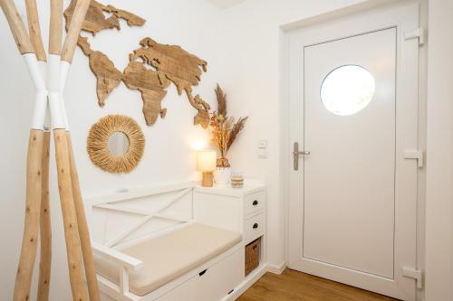 a white room with a white dresser and a mirror at NordseeResort Tossens - Seaside Corner in Tossenserdeich