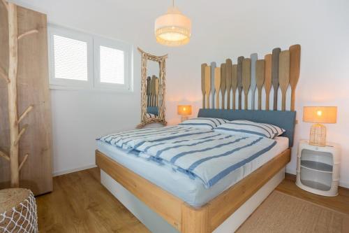 a bedroom with a large bed with a wooden headboard at NordseeResort Tossens - Seaside Corner in Tossenserdeich