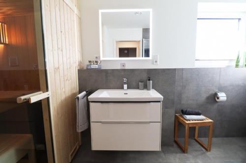 Un baño con un lavabo blanco y un espejo. en Küste33-15 - Strandnest, en Tossenserdeich
