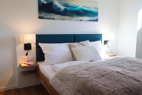 una cama con cabecera azul y almohadas blancas en Küste33-15 - Strandnest, en Tossenserdeich