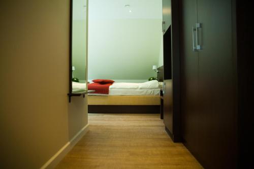 a hallway with a bed in a room with a mirror at Bramslevgaard in Hobro