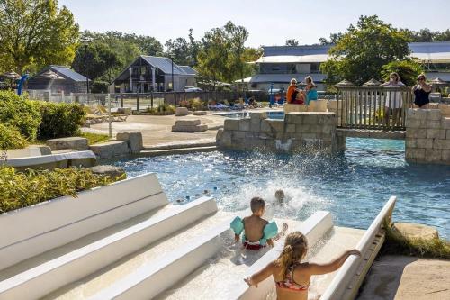 two children playing in the water at a water park at ZEcamping 5 étoiles familial animaux acceptés in Sainte-Catherine-de-Fierbois