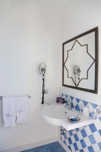 a bathroom with a sink and a mirror at Hotel Cutimare - Aeolian Charme in Acquacalda