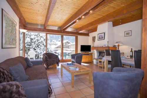 un soggiorno con un divano e un tavolo di Chalet Résidence Chantey Mourry 67 - Happy Rentals a Chamonix-Mont-Blanc